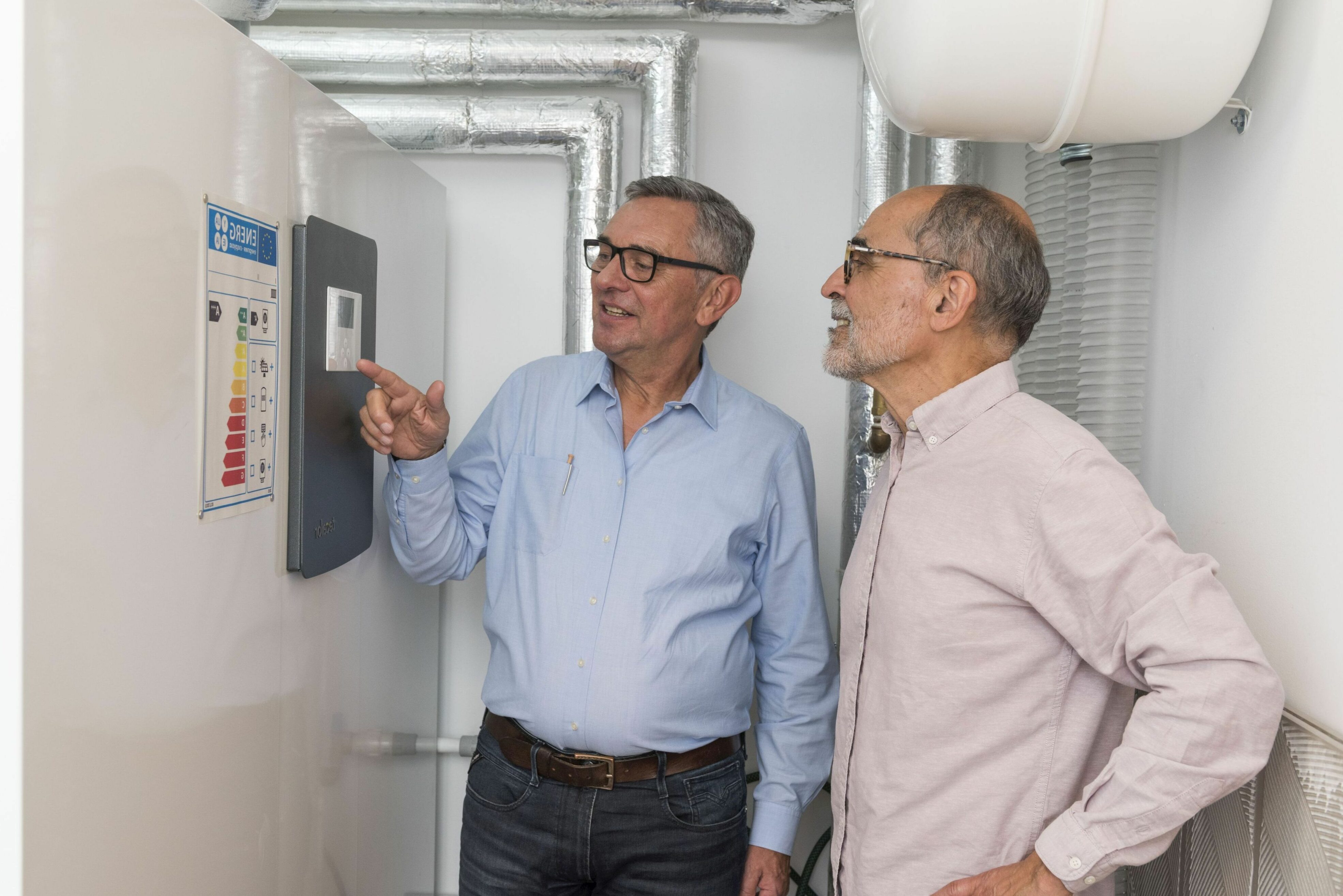 Zwei Männer im Heizungsraum vor Heiztechnik