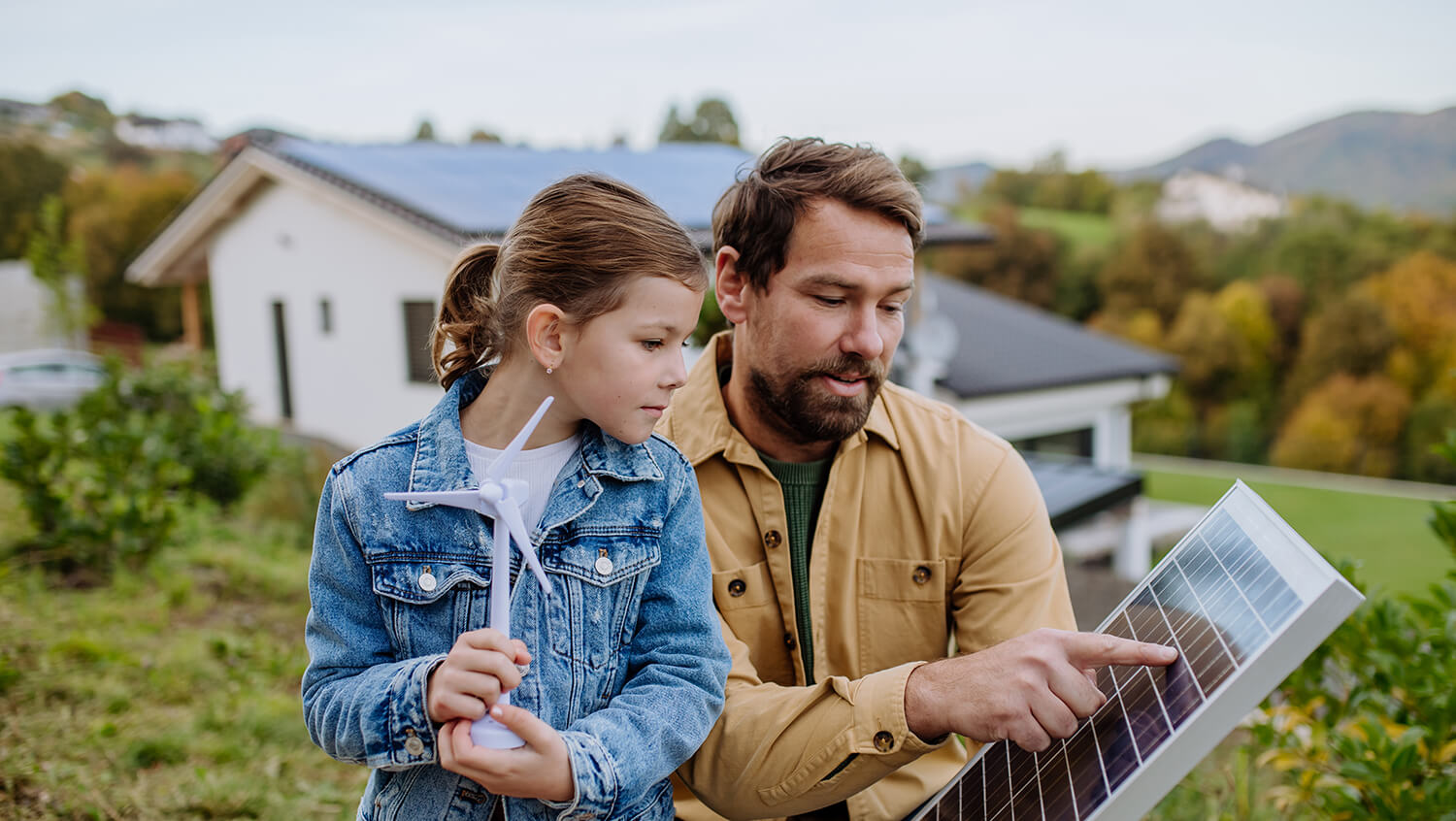 Ein Vater zeigt seiner Tochter eine Photovoltaik-Paneele und erklärt etwas.